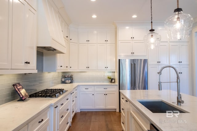 kitchen featuring stainless steel appliances, dark wood-style flooring, a sink, white cabinets, and decorative backsplash