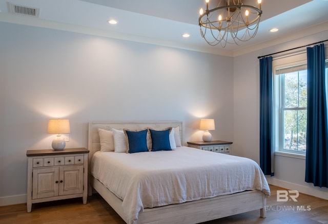 bedroom with light wood finished floors, multiple windows, visible vents, and a notable chandelier