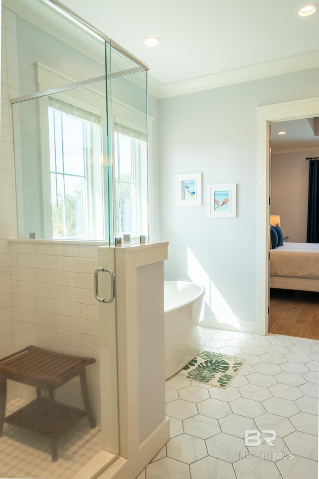 ensuite bathroom featuring connected bathroom, ornamental molding, a freestanding tub, a shower stall, and recessed lighting