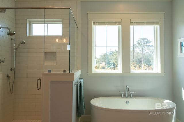 bathroom with a freestanding tub and a shower stall