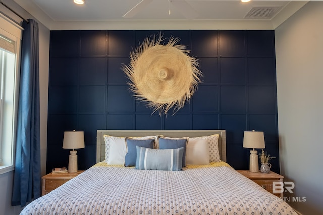 bedroom with visible vents, a decorative wall, and recessed lighting