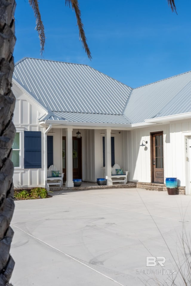 back of house featuring metal roof and board and batten siding