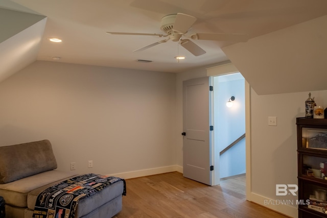 sitting room with light wood finished floors, baseboards, and vaulted ceiling