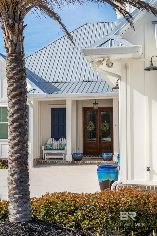 doorway to property with metal roof, french doors, a standing seam roof, and board and batten siding