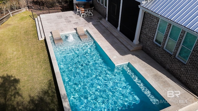 view of swimming pool with fence, a lawn, and a patio