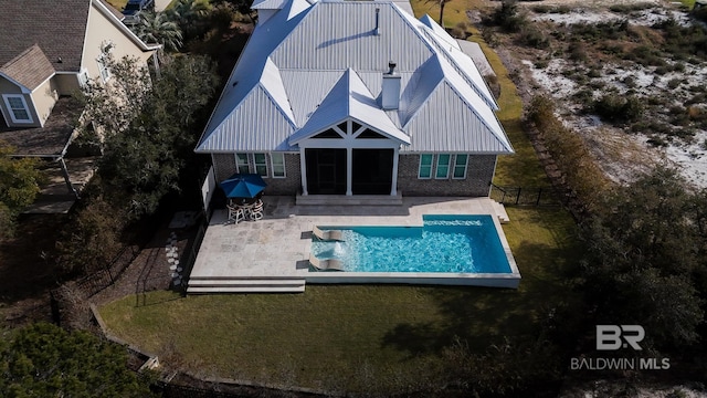 pool with a lawn, a patio area, and fence