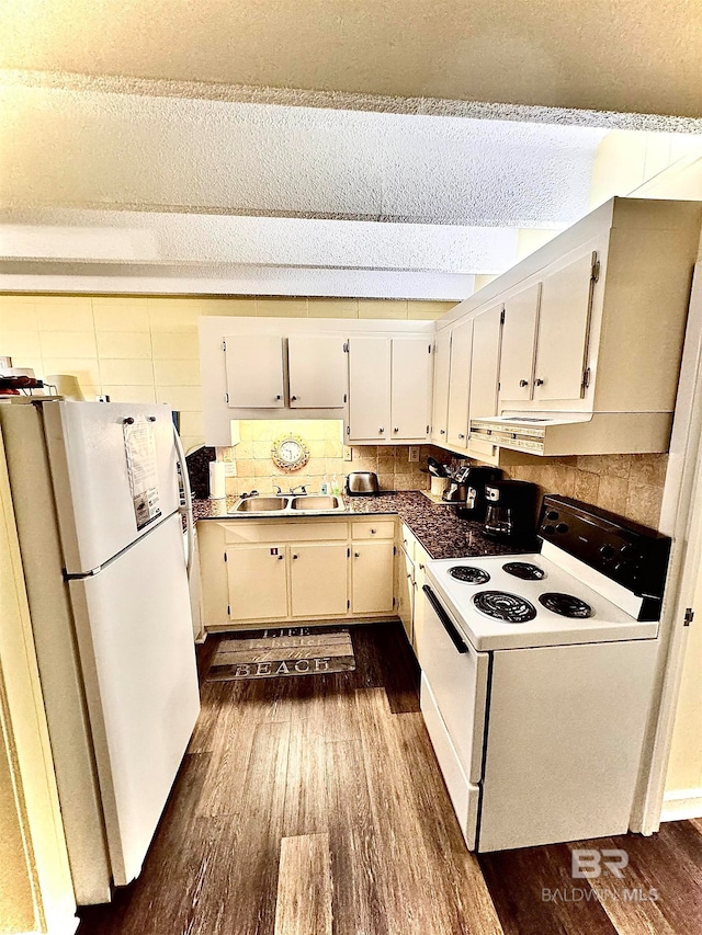 kitchen featuring sink, tasteful backsplash, dark hardwood / wood-style flooring, range hood, and white appliances