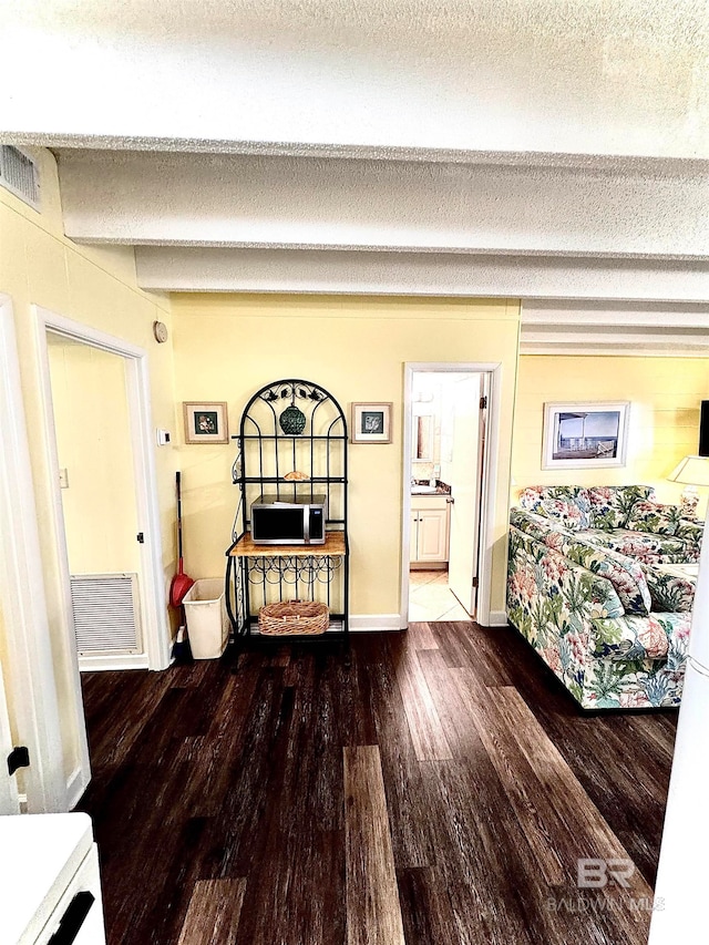 bedroom featuring hardwood / wood-style floors, a textured ceiling, and ensuite bath