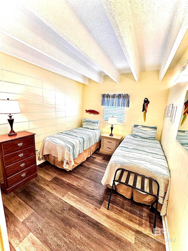 bedroom featuring beam ceiling, a textured ceiling, and dark hardwood / wood-style floors