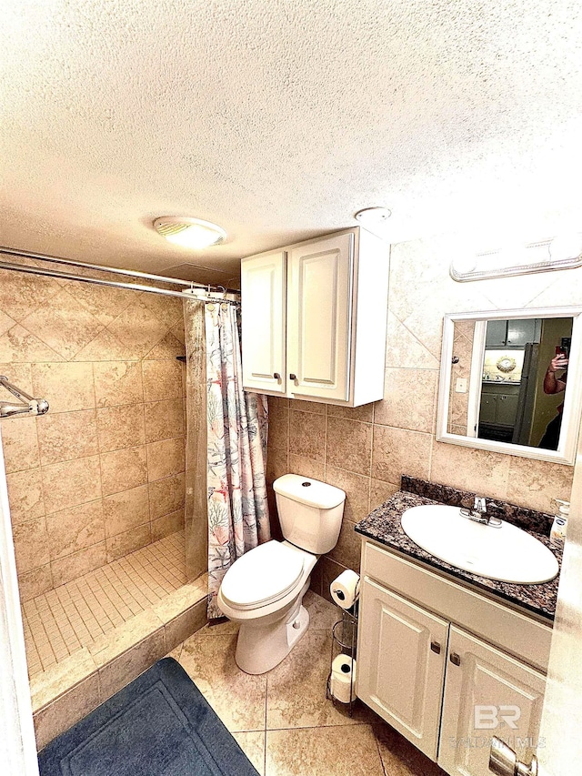 bathroom with tile patterned flooring, a shower with curtain, a textured ceiling, and vanity