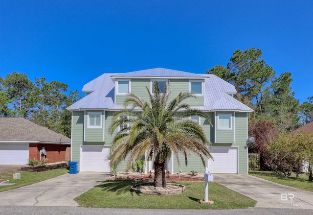 4209 Antigua Ct, Orange Beach, AL 36561 - raised beach house with concrete driveway, a garage, and metal roof