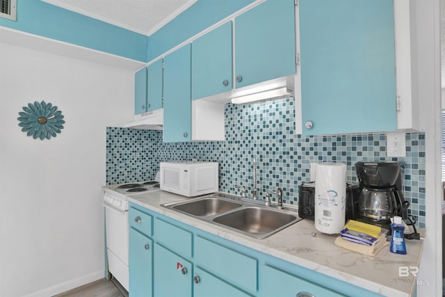 325 E 22nd Ave Unit 8, Gulf Shores, AL 36542 - kitchen with white appliances, under cabinet range hood, blue cabinetry, decorative backsplash, and crown molding