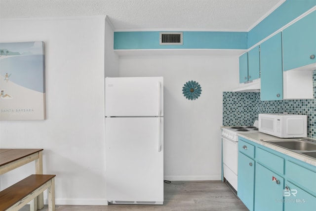 325 E 22nd Ave Unit 8, Gulf Shores, AL 36542 - kitchen with white appliances, under cabinet range hood, blue cabinets, light wood-style flooring, and decorative backsplash