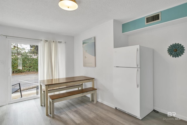 325 E 22nd Ave Unit 8, Gulf Shores, AL 36542 - dining room featuring wood finished floors, a textured ceiling, and baseboards