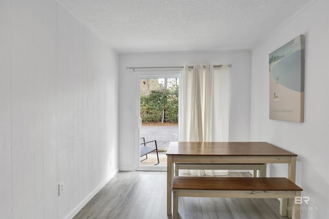 325 E 22nd Ave Unit 8, Gulf Shores, AL 36542 - unfurnished dining area featuring a textured ceiling, wood finished floors, and baseboards