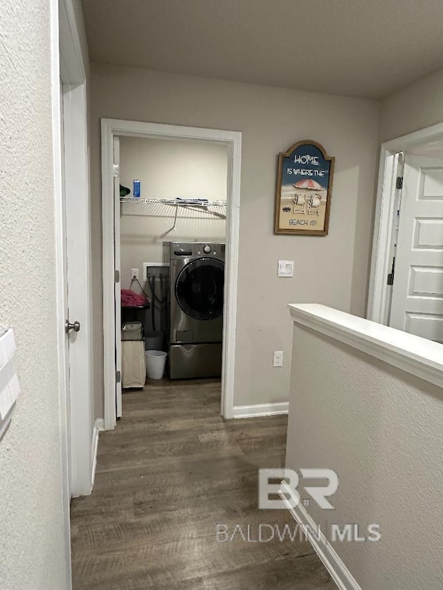 hall featuring baseboards, washer / clothes dryer, and dark wood finished floors