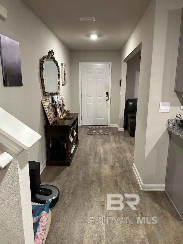 hallway with dark wood-style flooring and baseboards