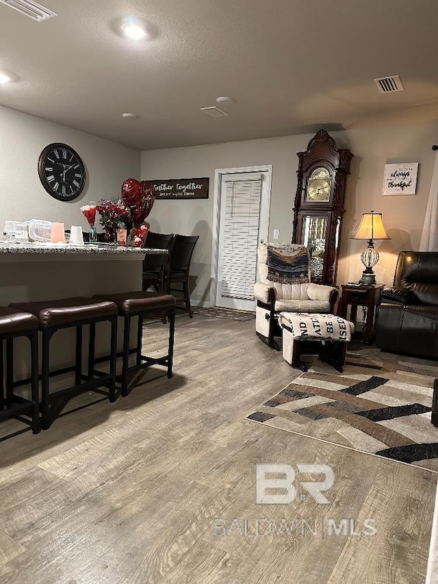 interior space with a textured ceiling, visible vents, and wood finished floors