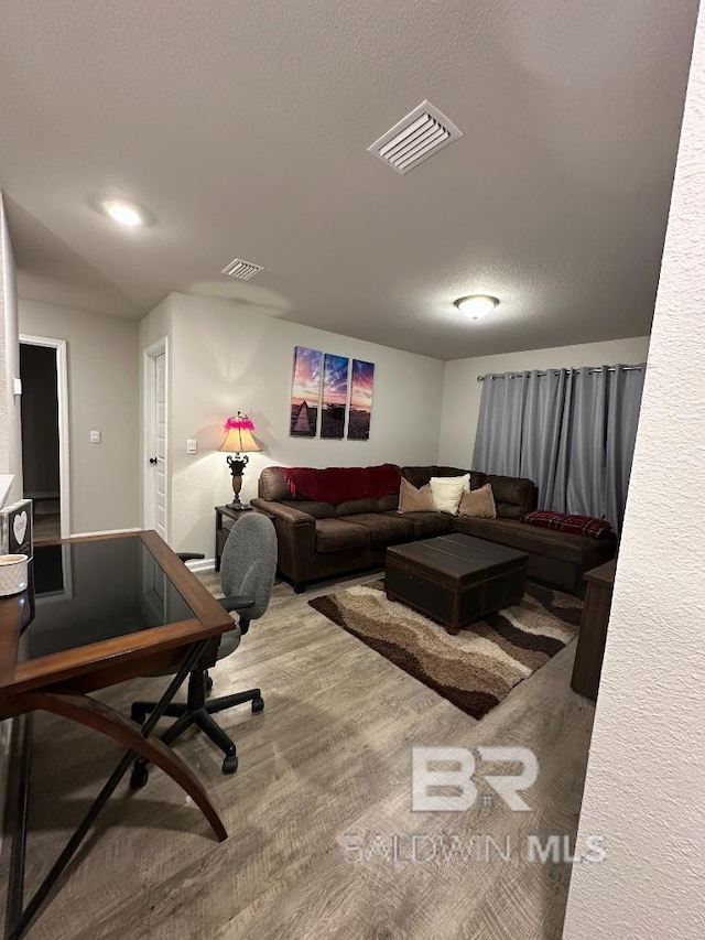 living area featuring a textured ceiling and visible vents