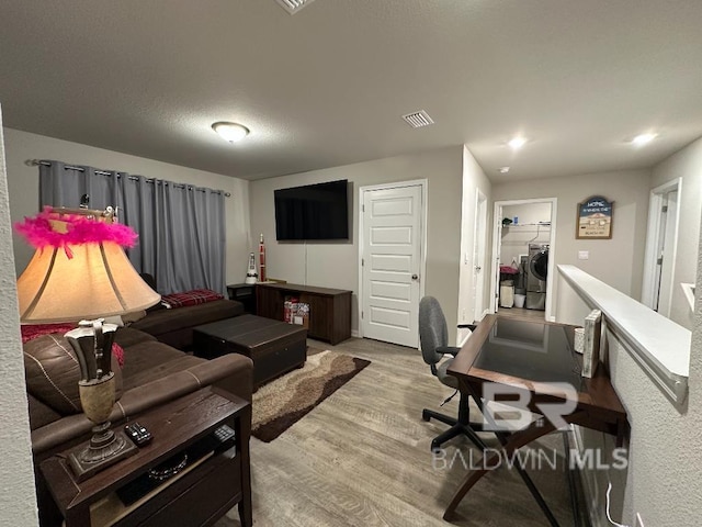 living area with recessed lighting, visible vents, independent washer and dryer, and light wood-style flooring