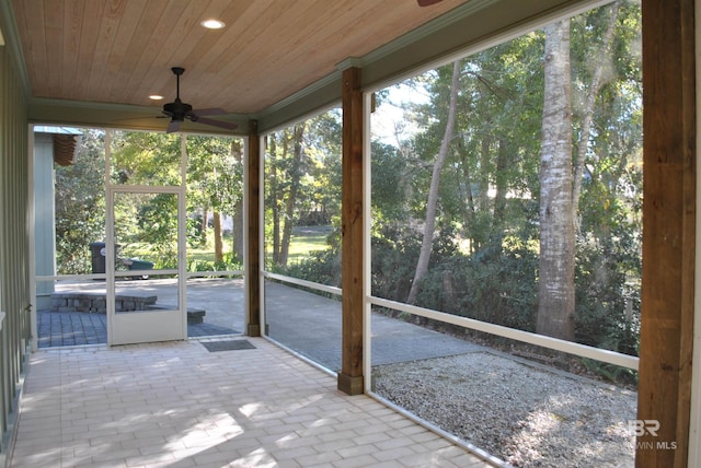 unfurnished sunroom with ceiling fan and wood ceiling