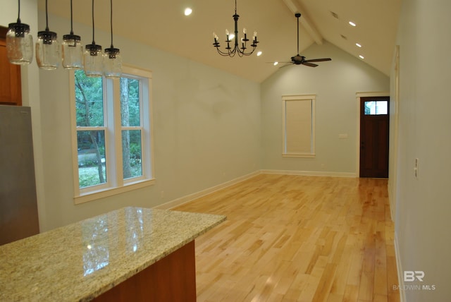 unfurnished dining area with light wood-type flooring, vaulted ceiling with beams, ceiling fan with notable chandelier, and a wealth of natural light