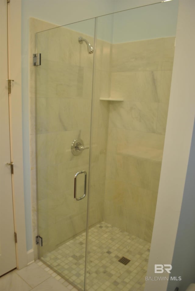 bathroom featuring tile patterned flooring and a shower with shower door