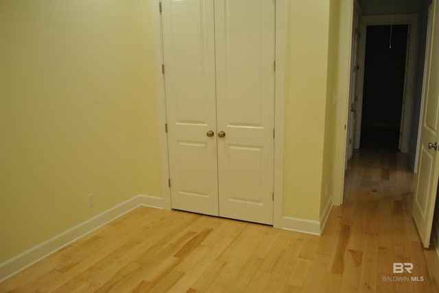 unfurnished bedroom featuring light hardwood / wood-style flooring and a closet