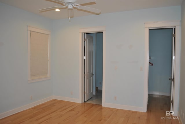 unfurnished bedroom with light hardwood / wood-style floors, a spacious closet, and ceiling fan