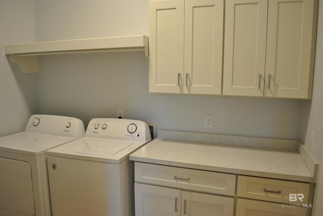 washroom featuring washer and dryer and cabinets