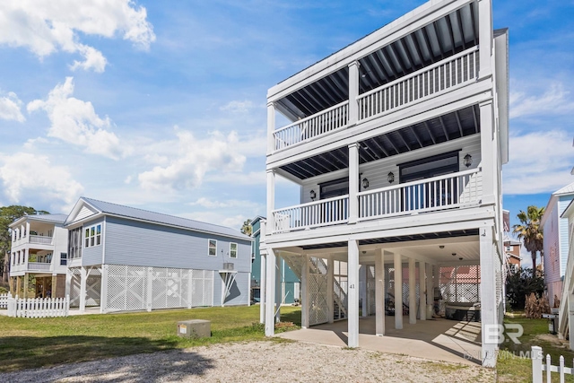 back of property featuring driveway, fence, a yard, a carport, and stairs