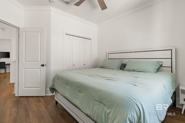 bedroom featuring visible vents, dark wood-type flooring, ornamental molding, a closet, and ceiling fan