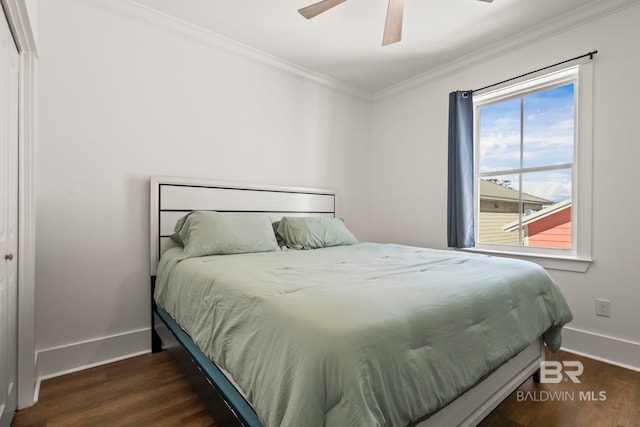 bedroom featuring baseboards, wood finished floors, ornamental molding, and a ceiling fan