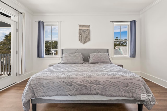 bedroom with multiple windows, access to exterior, dark wood-style flooring, and crown molding