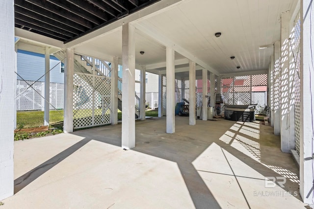 view of patio featuring a carport, stairs, and fence