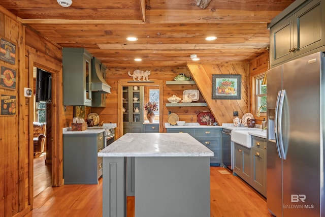 kitchen featuring light wood-type flooring, stainless steel appliances, a center island, and wood ceiling