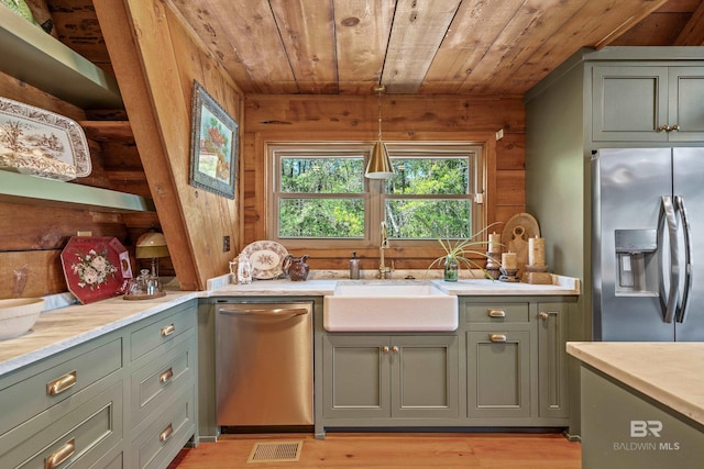 kitchen with green cabinetry, wood ceiling, a sink, and stainless steel appliances