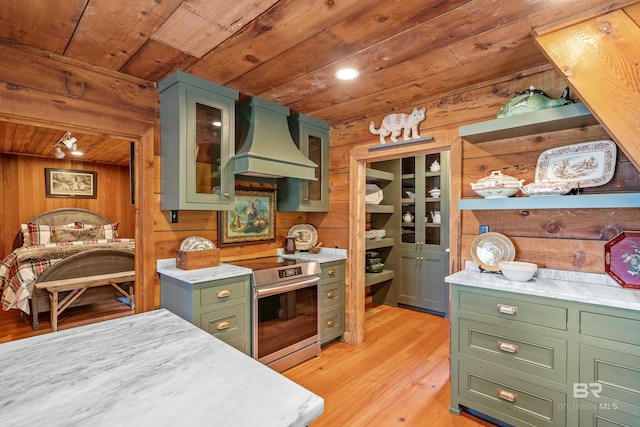 kitchen with green cabinets, stainless steel range with electric stovetop, light countertops, custom range hood, and wooden ceiling