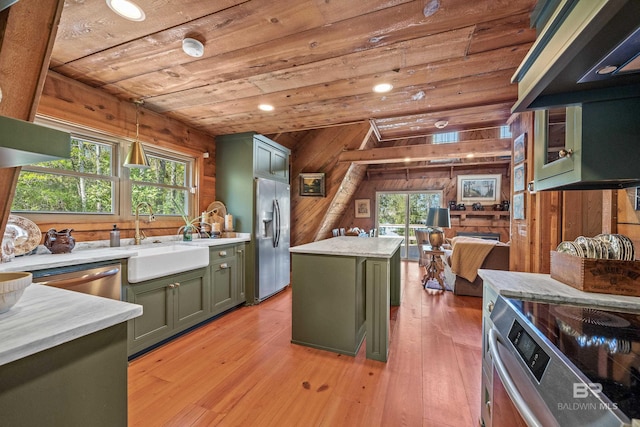 kitchen with green cabinets, wooden ceiling, a sink, wooden walls, and appliances with stainless steel finishes