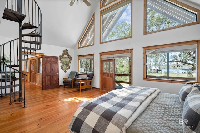 bedroom with high vaulted ceiling and wood finished floors