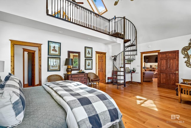 bedroom featuring a high ceiling and light wood-type flooring