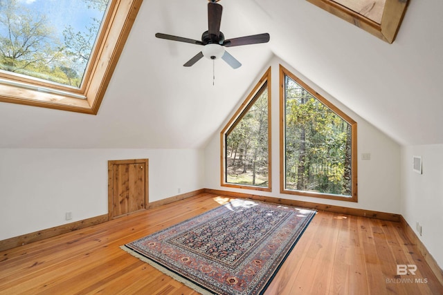additional living space with hardwood / wood-style flooring, baseboards, and lofted ceiling