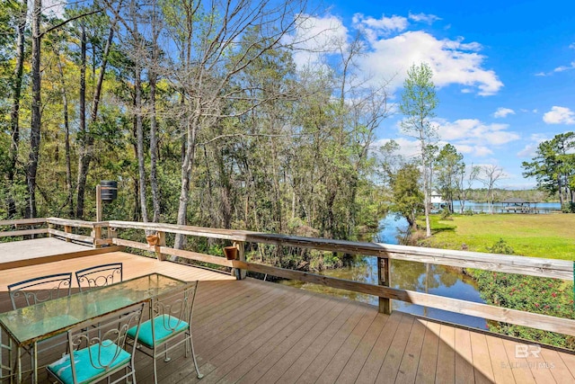wooden deck with a lawn and a water view