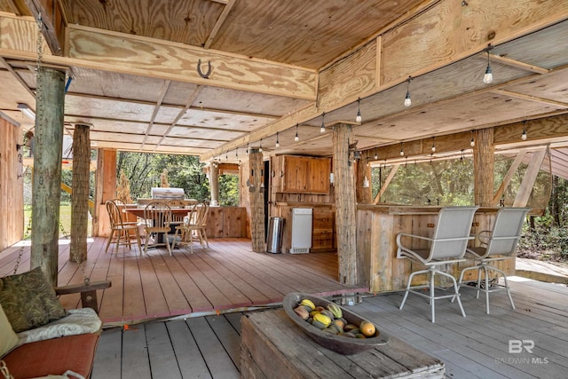 wooden deck with outdoor dining space and grilling area