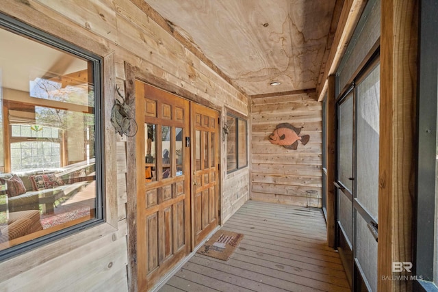 corridor featuring wood walls, wood ceiling, and hardwood / wood-style flooring