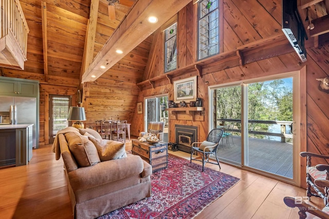 living room with high vaulted ceiling, wooden ceiling, wooden walls, beamed ceiling, and light wood-style floors