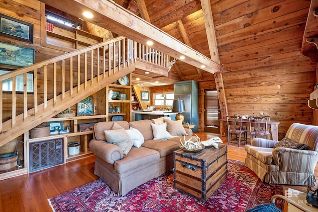 living area featuring visible vents, wooden walls, hardwood / wood-style flooring, stairway, and wood ceiling