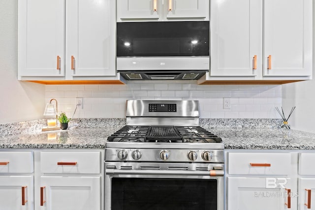 kitchen with appliances with stainless steel finishes, tasteful backsplash, and white cabinetry