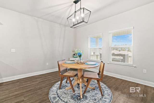 dining area with a notable chandelier and dark hardwood / wood-style flooring