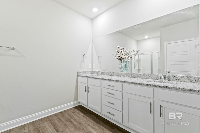 bathroom with vanity, hardwood / wood-style flooring, and walk in shower